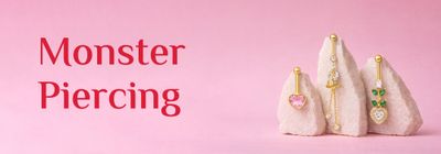 Monster Piercing gold jewellery hero banner, gold studs, hoops and rings laid on a marble surface